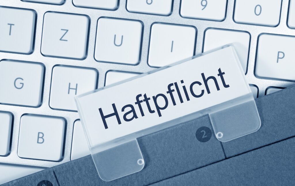 Ordner zur Haftpflicht vor einer Laptoptastatur